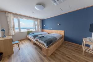 a bedroom with a bed and a large window at Hotel Kifu Club Shiretoko in Shari