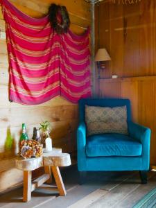a blue chair and a table in a room with a blanket at Ne Pakku Manja Family Home in Rantepao