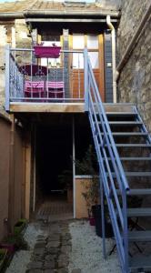 a staircase leading up to a house with pink chairs at Loc'apparts in Beaumont-sur-Oise