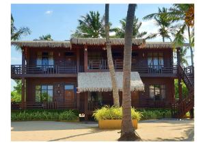 a large building with palm trees in front of it at Nilaveli Beach Resort - Level 1 Certified in Nilaveli