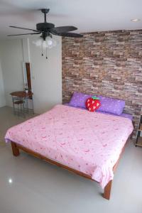 a bed in a room with a brick wall at Ingkho Khao Kho อิงค้อ เขาค้อ in Khao Kho