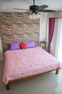 a bedroom with a pink bed with a brick wall at Ingkho Khao Kho อิงค้อ เขาค้อ in Khao Kho