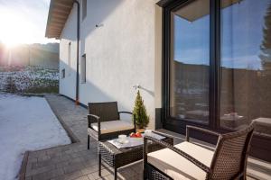een patio met stoelen, een tafel en een raam bij Appartement Sophie in Söll