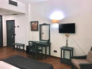 a living room with a table and a mirror at Hotel Almagro in Almagro