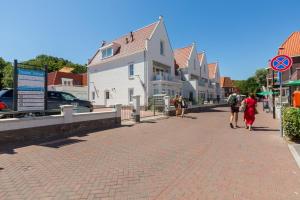 a group of people walking down a brick street at Appartement - Kaapduinseweg 13 Dishoek M Luxe 6 personen in Koudekerke