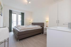 a bedroom with a bed and a sink in it at Appartement - Kaapduinseweg 13 Dishoek M Luxe 6 personen in Koudekerke