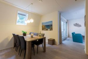 a dining room and living room with a table and chairs at Appartement - Kaapduinseweg 13 Dishoek M Luxe 6 personen in Koudekerke