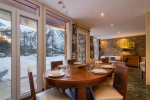 une salle à manger avec une table et une grande fenêtre dans l'établissement Chalet Glacier - Happy Rentals, à Chamonix-Mont-Blanc