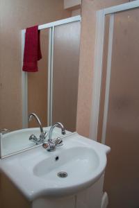 a bathroom with a white sink and a mirror at Bungalow 6 personen in s-Gravenzande