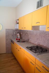 ス・グラーヴェンザンデにあるBungalow 6 personenのキッチン(黄色のキャビネット、シンク付)