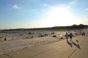 two people walking down a sidewalk on the beach at Bungalow 8 personen in s-Gravenzande