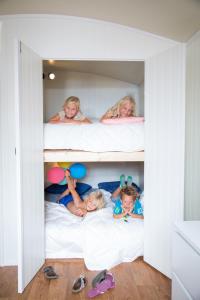 a group of children laying in bunk beds at Pipowagen op het park in 's-Gravenzande