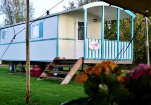 a blue and white tiny house on a trailer at Pipowagen op het park in 's-Gravenzande