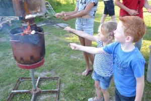 a group of people standing around a grill at Pipowagen op het strand in s-Gravenzande