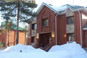 a red brick building with snow in front of it at Ekaterinin Dvor Hotel in Surgut