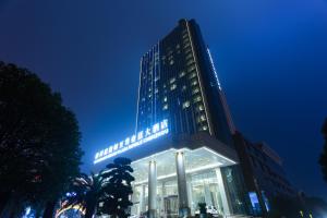 um edifício alto com luzes acesas à noite em Wyndham Grand Plaza Royale Chenzhou em Chenzhou