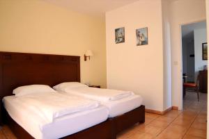 Hapimag Ferienwohnungen Puerto de la Cruz في بويرتو دي لا كروث: غرفة نوم بسريرين مع شراشف بيضاء