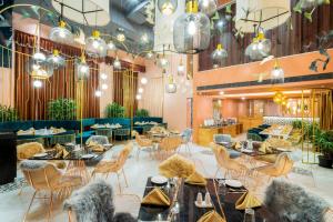 a restaurant with tables and chairs and chandeliers at Little Mastiff Moshi by OTHPL in Pune
