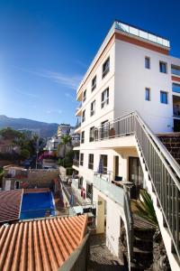 a white building with a balcony and a swimming pool at Hapimag Ferienwohnungen Puerto de la Cruz in Puerto de la Cruz