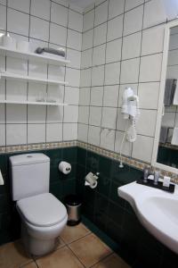 a bathroom with a toilet and a sink and a phone at Hapimag Ferienwohnungen Puerto de la Cruz in Puerto de la Cruz