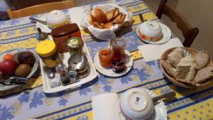 een tafel met een blauwe en gele tafeldoek met voedsel bij B&BAcacias in Croix