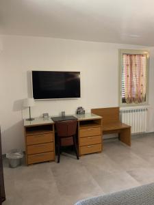 Habitación con escritorio y TV en la pared. en Hotel Villa Archirafi en Palermo