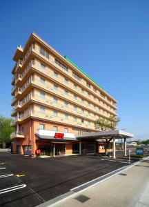 un grand bâtiment avec un parking en face de celui-ci dans l'établissement Green Hotel Yes Nagahama Minatokan, à Nagahama