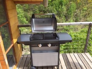 a grill sitting on a porch on a deck at Chalet sur pilotis avec piscine privée in Lucéram