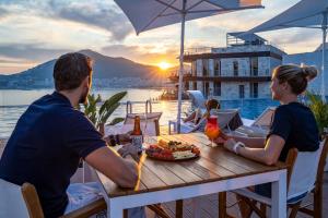 a man and woman sitting at a table with a plate of food at Dukley Hotel & Resort in Budva