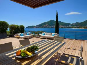 a bowl of fruit on a wooden table on a deck at Dukley Hotel & Resort in Budva