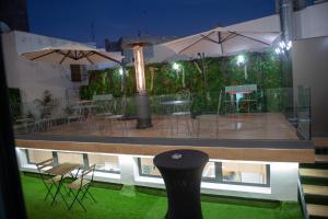 Elle offre une vue sur un patio doté de chaises, de tables et de parasols. dans l'établissement NJ Hotel Rabat, à Rabat