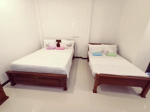 Habitación con 2 camas individuales y paredes blancas. en Sea And River View Mirissa, en Mirissa