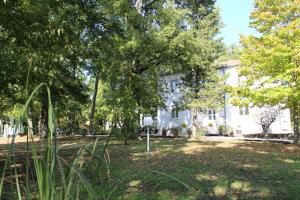 une maison blanche avec des arbres devant elle dans l'établissement Villa La Casa Bianca, à Podere Pian Mucini