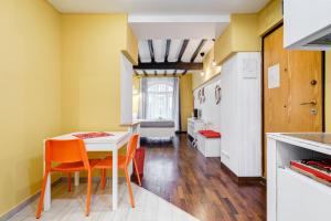 a kitchen with a table and chairs and a refrigerator at Trastevere Suite in Rome