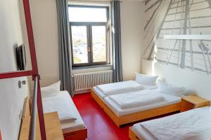 a room with two beds and a window at havenhostel Bremerhaven in Bremerhaven