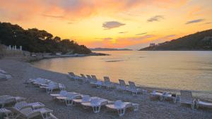 a group of chairs on the beach at sunset at Hotel Vis in Dubrovnik