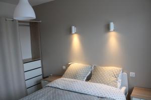 1 dormitorio con 1 cama y 2 luces en la pared en Appartement de 57m2 vue sur mer et plage, en Le Portel