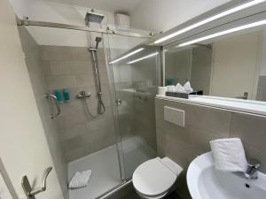 a bathroom with a shower and a toilet and a sink at Hotel Flensburger Hof in Flensburg