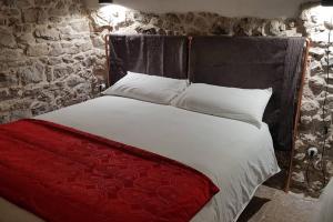 a bedroom with a bed with a red and white comforter at LA CASA DI ROSA in Rivisondoli