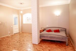 a bedroom with a bed with two red pillows at Monro - Heart of Lviv in Lviv