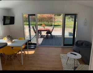 ein Wohnzimmer mit einem Tisch und einer Terrasse in der Unterkunft Beach Chalet SunHus - modernes Chalet in Ostseenähe in Scharbeutz