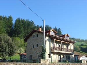 a large stone house with a balcony on top of it at Haras Aritza in Ojedo