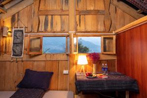 a room with a bed and a table with a window at Hmong Sister House and Trekking in Sa Pa +67 photos