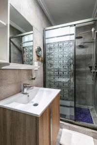 a bathroom with a sink and a shower at The Melva Guest House in Gaborone