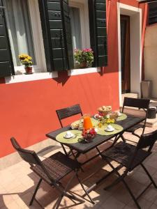 Ca' Alansari في البندقية: طاولة مع كراسي والطعام في الفناء