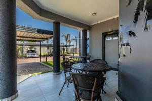 a patio with a table and chairs on a porch at The Melva Guest House in Gaborone