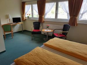 a room with two beds and a table and chairs at Eisenbahnwelten in Kurort Rathen