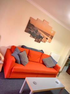 an orange couch with pillows in a living room at Cascais Spacious Getaway in Cascais