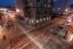 une rue urbaine vide la nuit avec des voitures et des bâtiments dans l'établissement Black and Red squares apartment, à Lviv