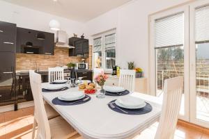 a kitchen and dining room with a white table and chairs at Holiday Home Istra with JACUZZI in Medulin